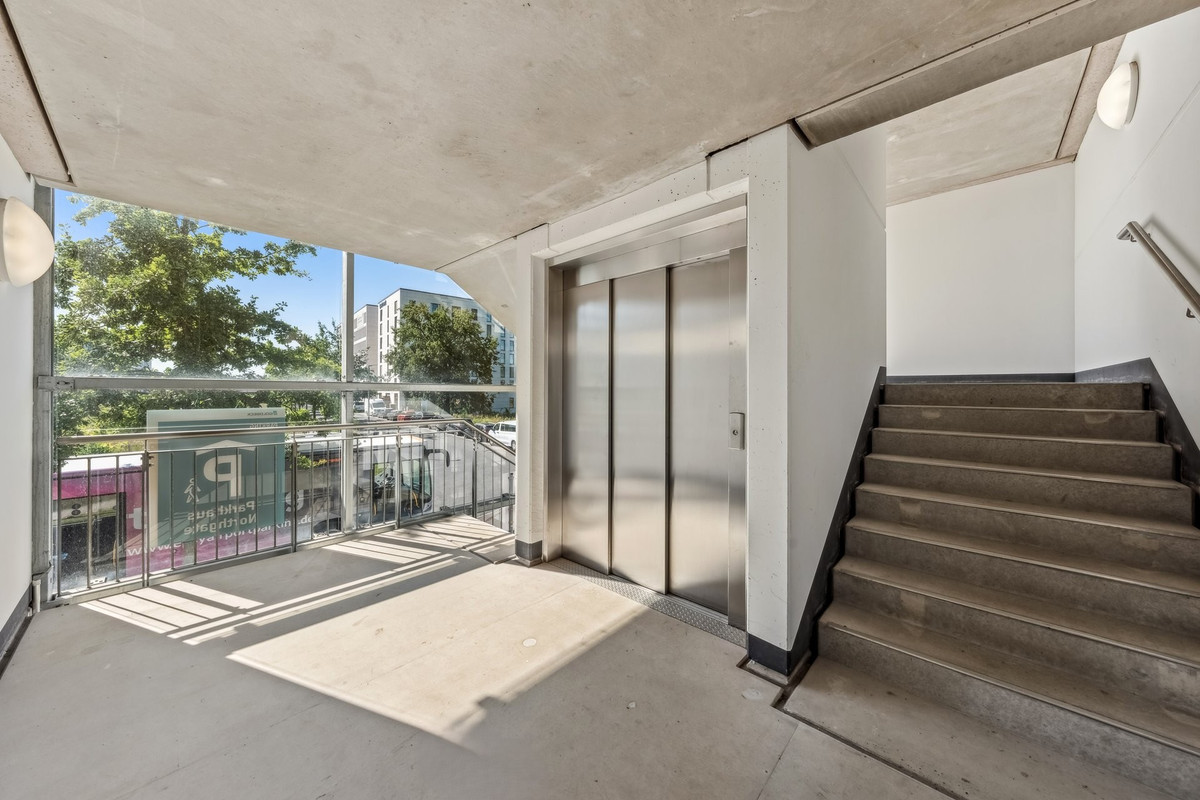 Helles Treppenhaus mit Aufzug im Easy Airport Parking Parkhaus am Flughafen Berlin Brandenburg (BER)