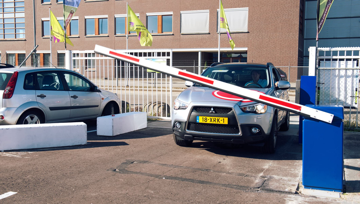 Zilveren auto wacht op opengaande slagboom op de parkeerplaats van Easy Airport Parking bij luchthaven Eindhoven (EIN)