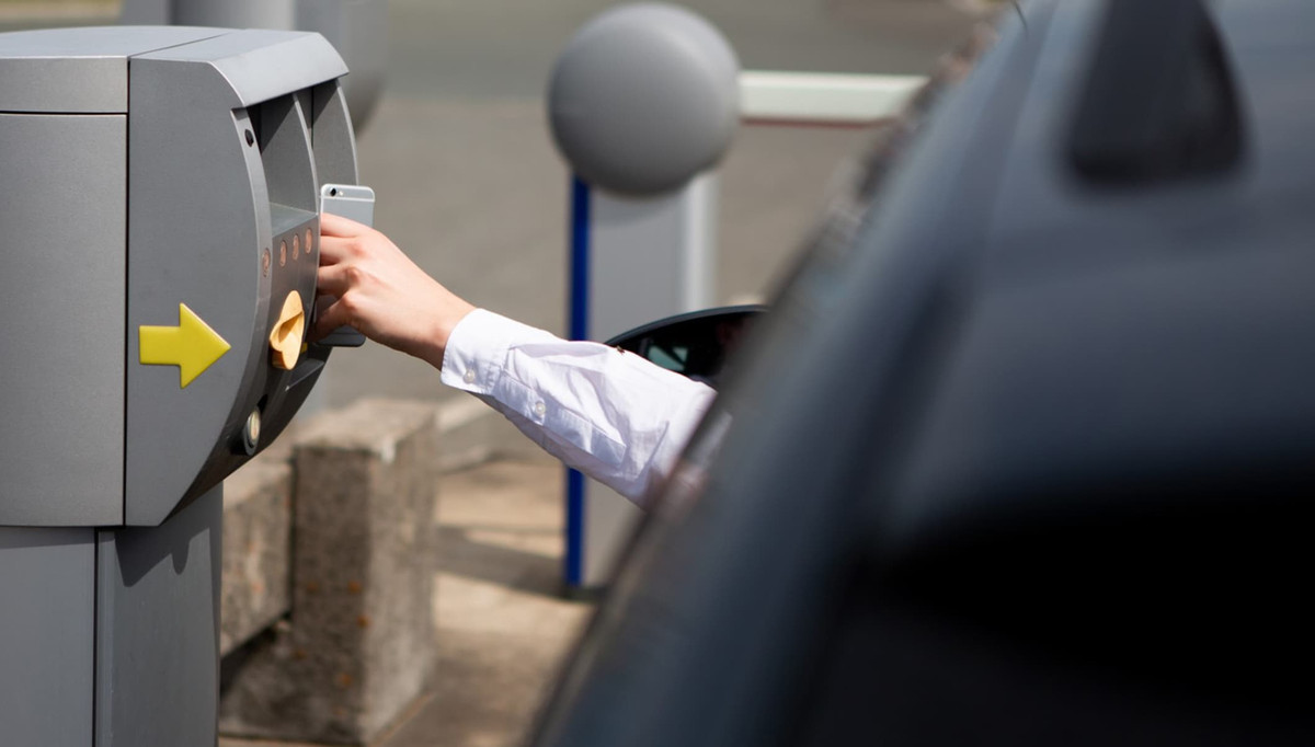 Driver checks in with a smartphone at the entrance of the parking lot of Easy Airport Parking at Frankfurt-Hahn Airport (HHN)